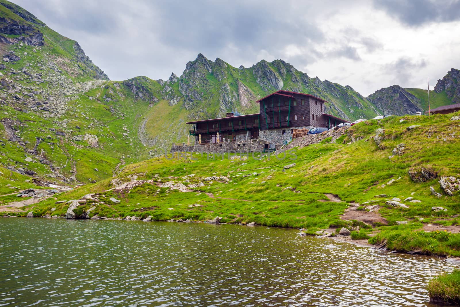 BALEA LAKE, ROMANIA - JUNE 24, 2012: Idyllic view with typical lodge on Balea Lake shore in Fagaras Mountains, Romania.