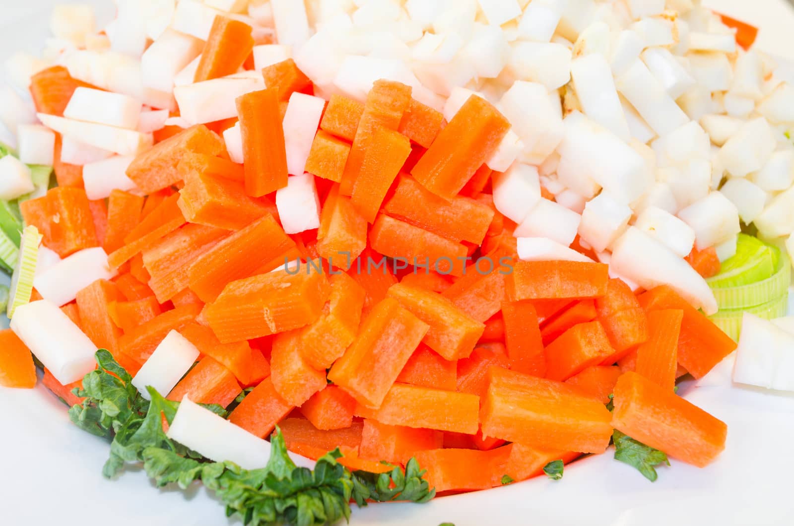 Various types of vegetables cut in front of white background