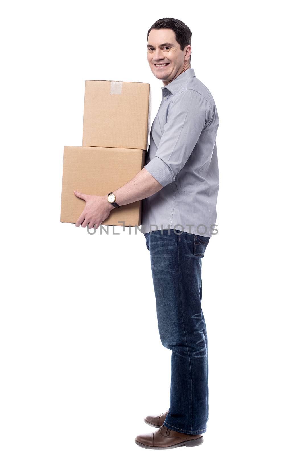 Sideways of casual man handling cardboard boxes