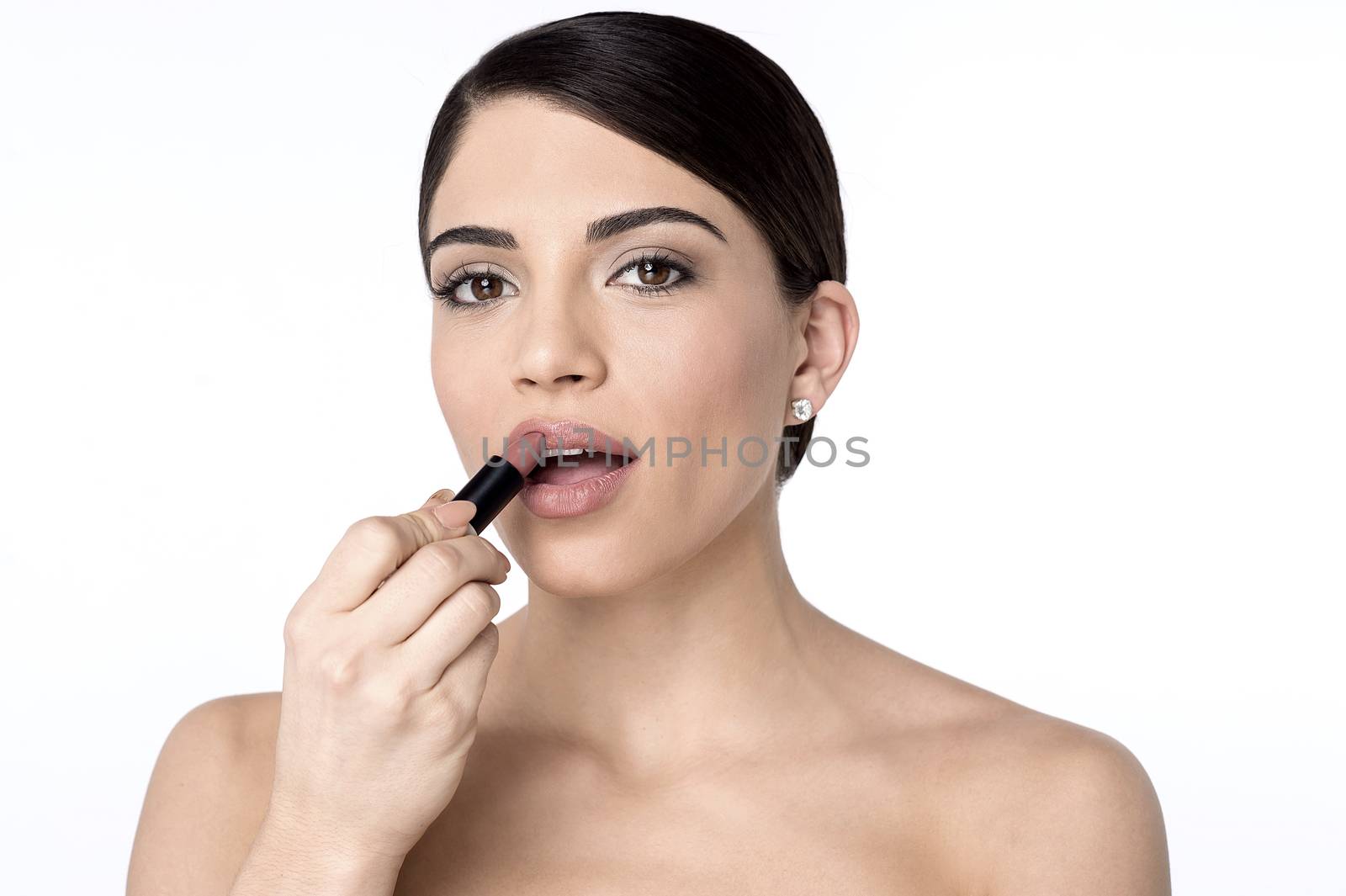 Pretty woman applying lipstick on her lips