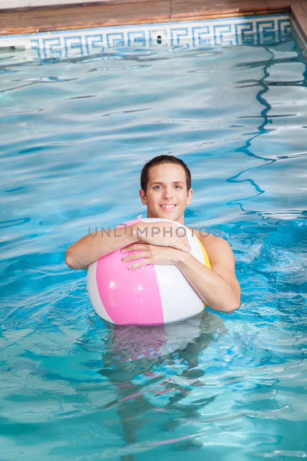 Man in the pool with inflatable ball