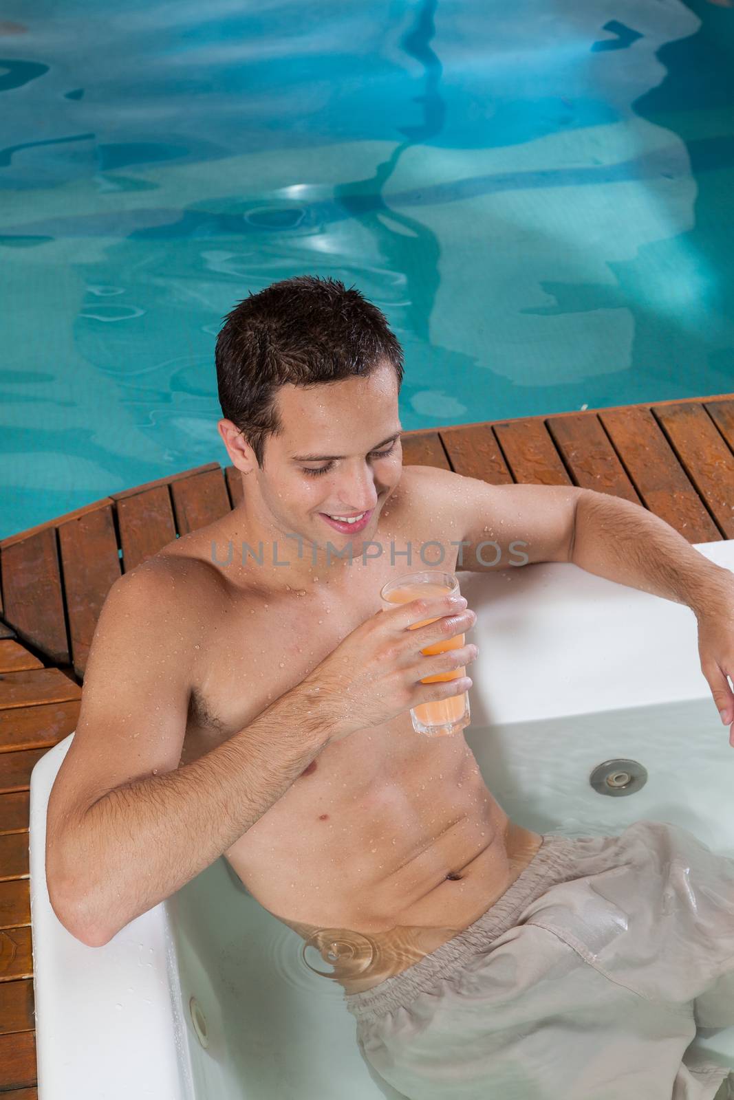 Man inside a jacuzzi drinking juice by ifilms