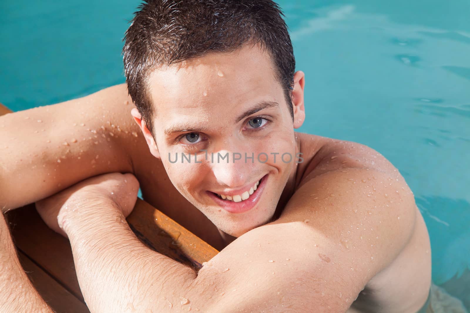 Man smiling in the edge of the pool by ifilms