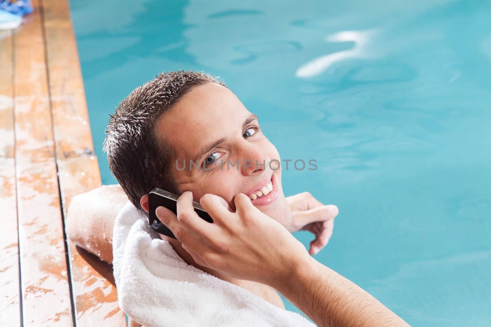 Man talking on mobile inside the pool by ifilms