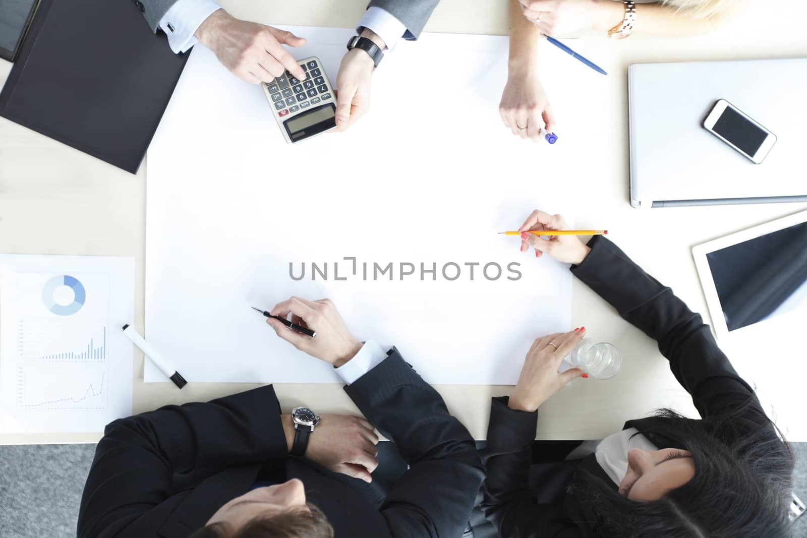 Business people sitting at table with electronic devices on meeting