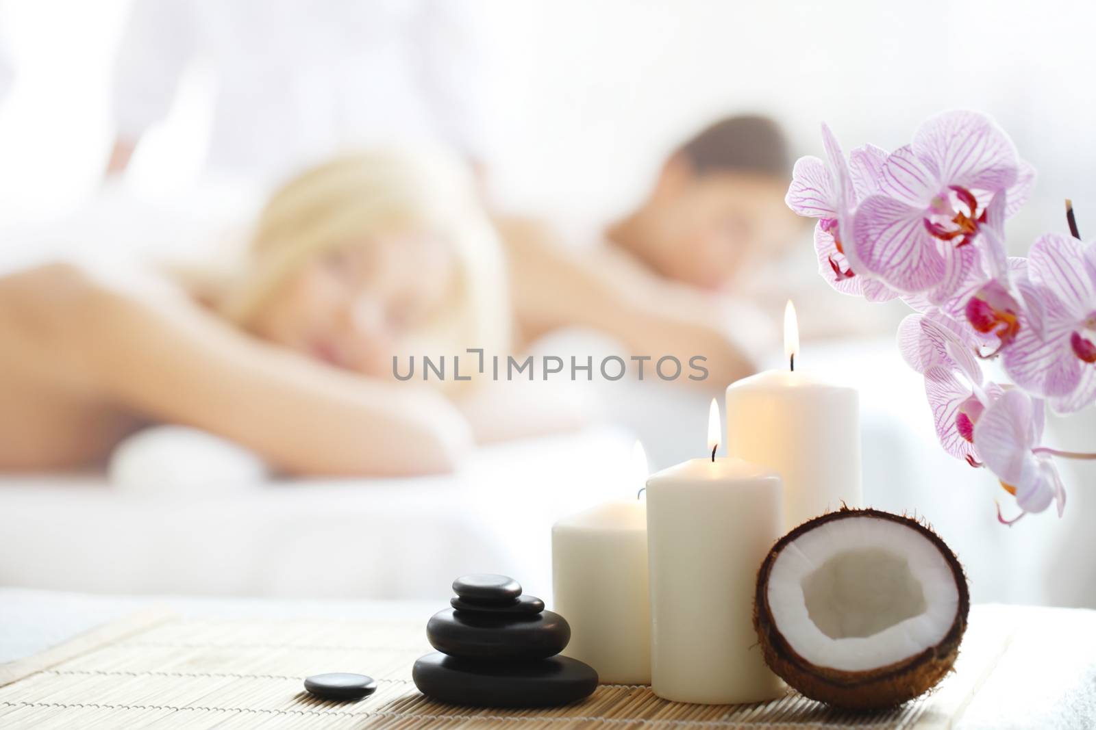 Spa massage tools and women getting massage on background