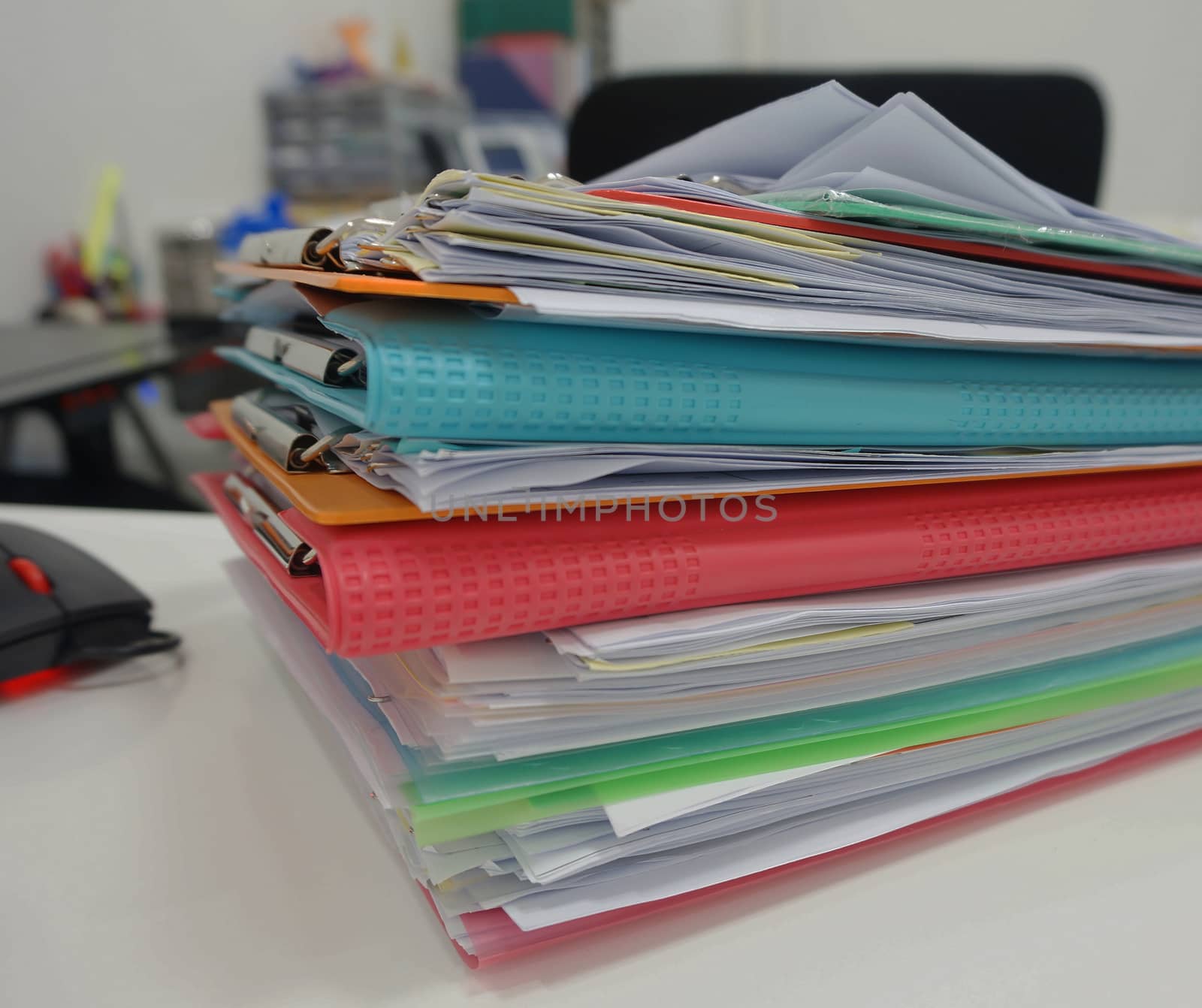 Stack of many color document folder on desk at office.                               