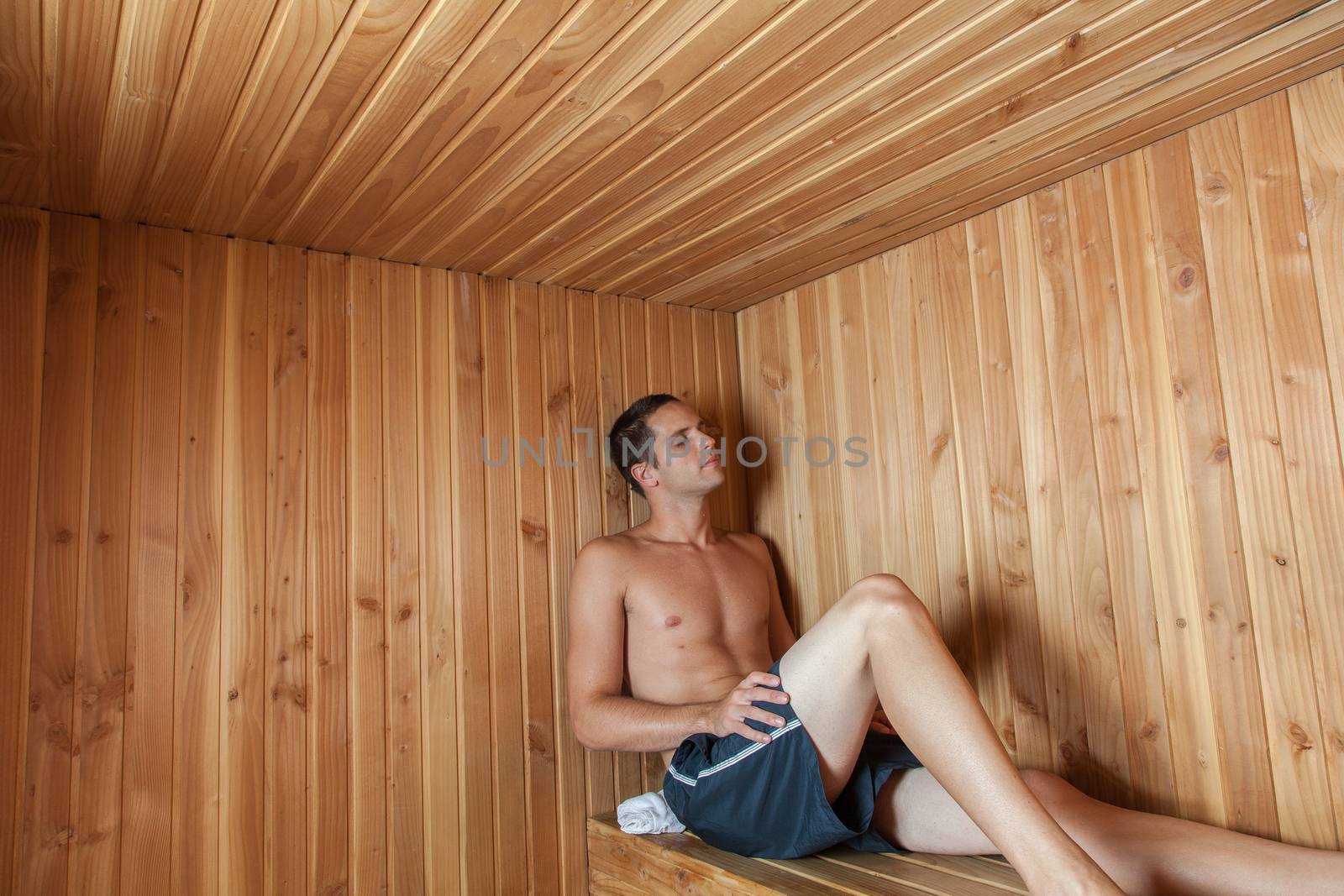Serious man sit inside the sauna by ifilms