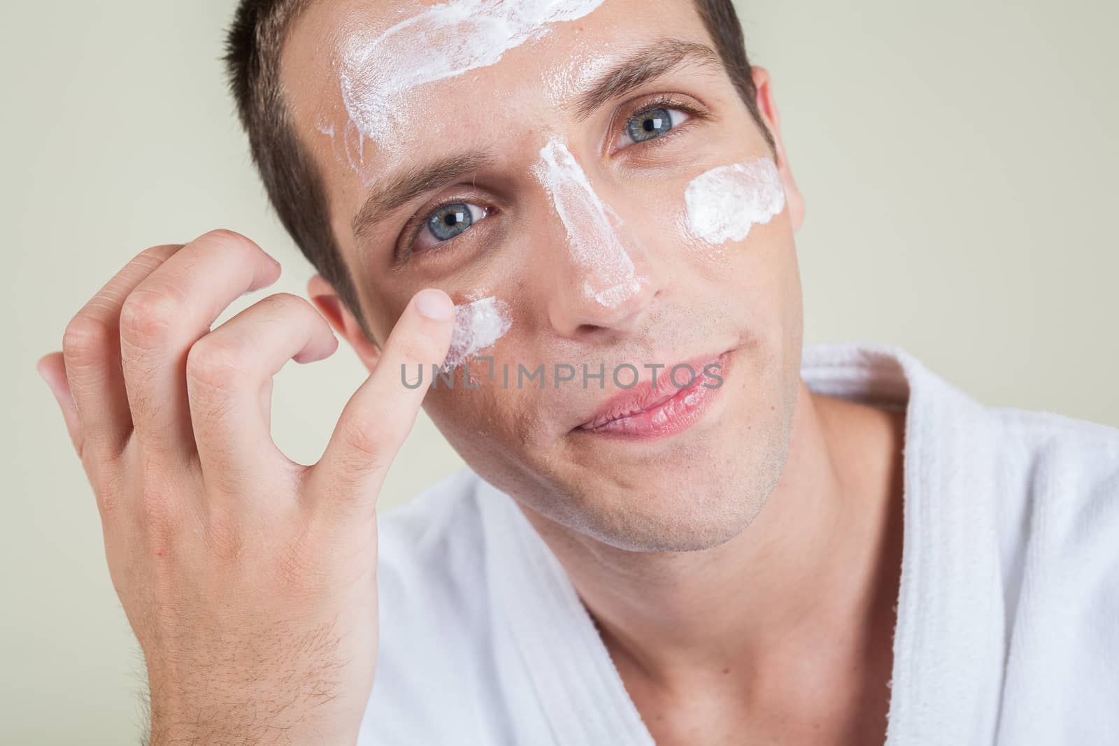 Serious man putting face cream with your finger by ifilms