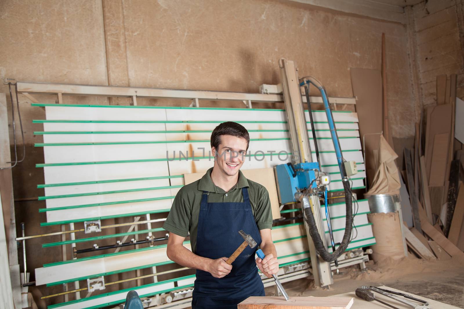 Smiling carpenter working with a chisel