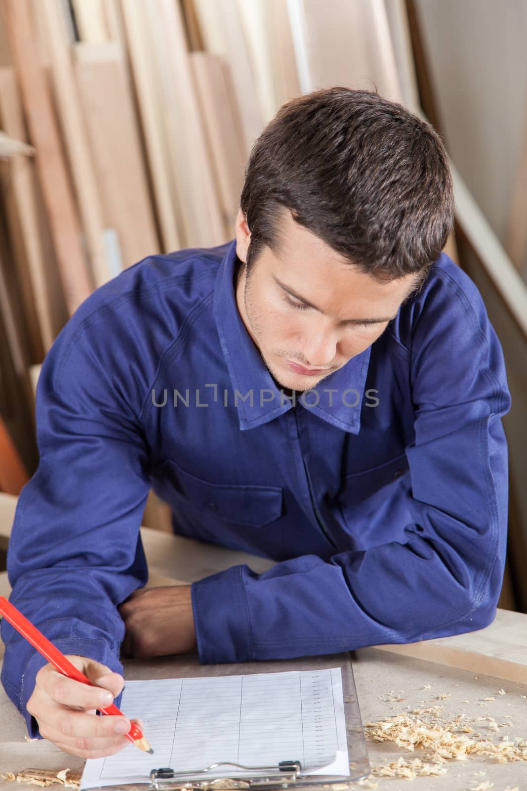 Guy writing in his workshop