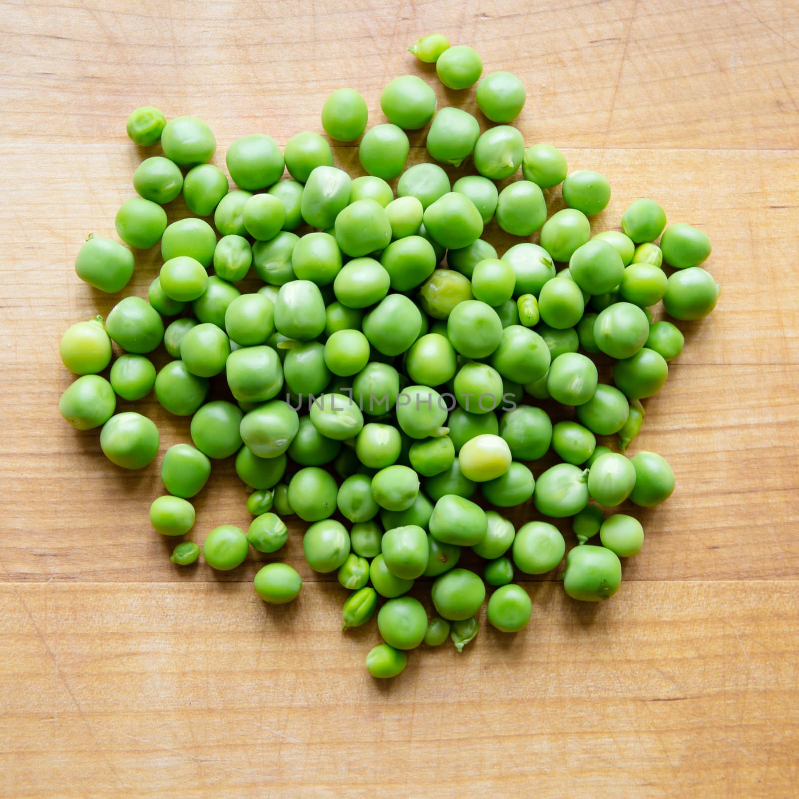 Pile of podded peas on wooden board