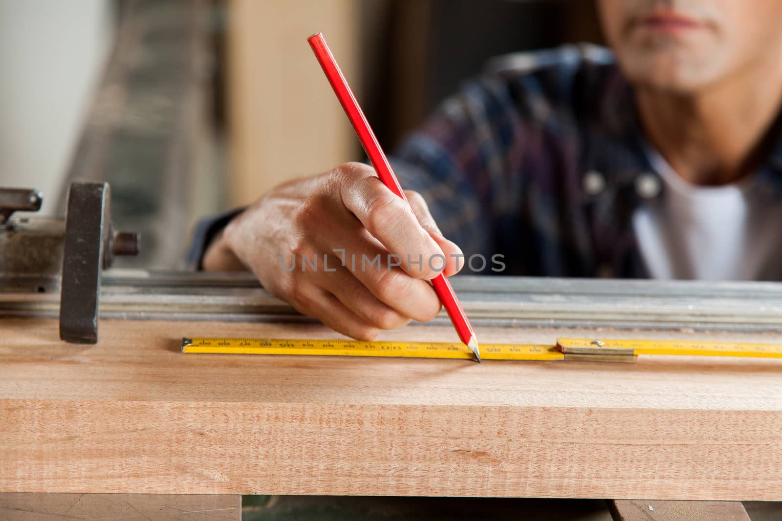 Serious carpenter marking a plank