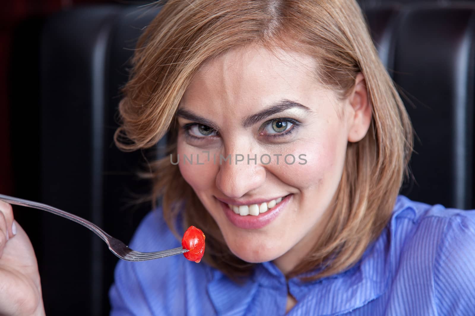 Woman is eating cherry