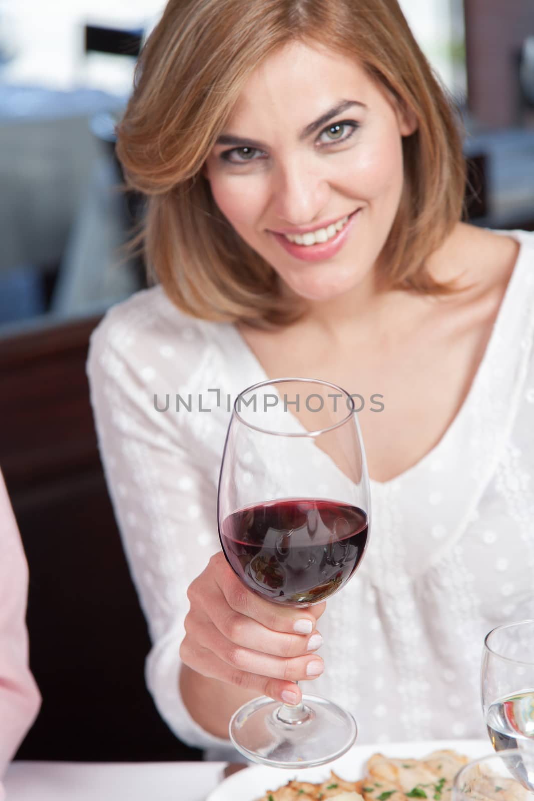 Woman is drinking a cup of wine
