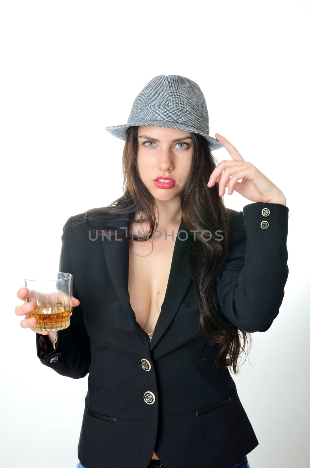 Girl holds glass with drink. Young female model puts dark tail-coat and classic hat.