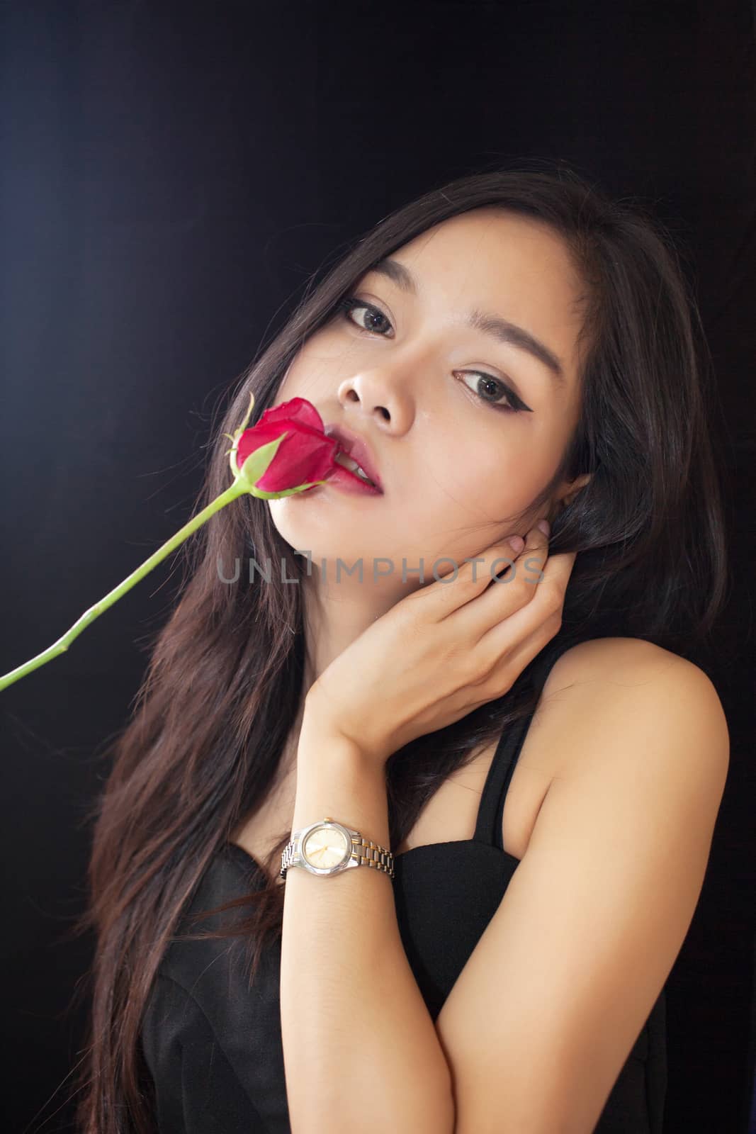 Beautiful asian women and red rose on black background .