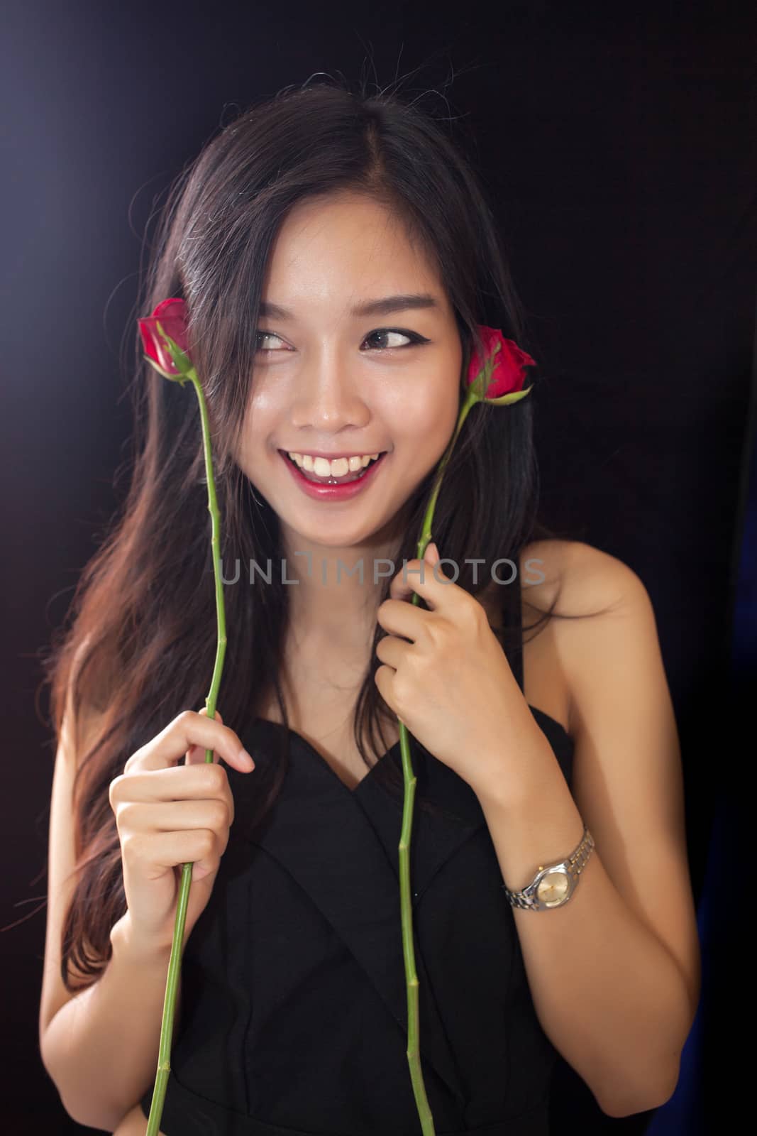 Beautiful asian women and red rose on black background .