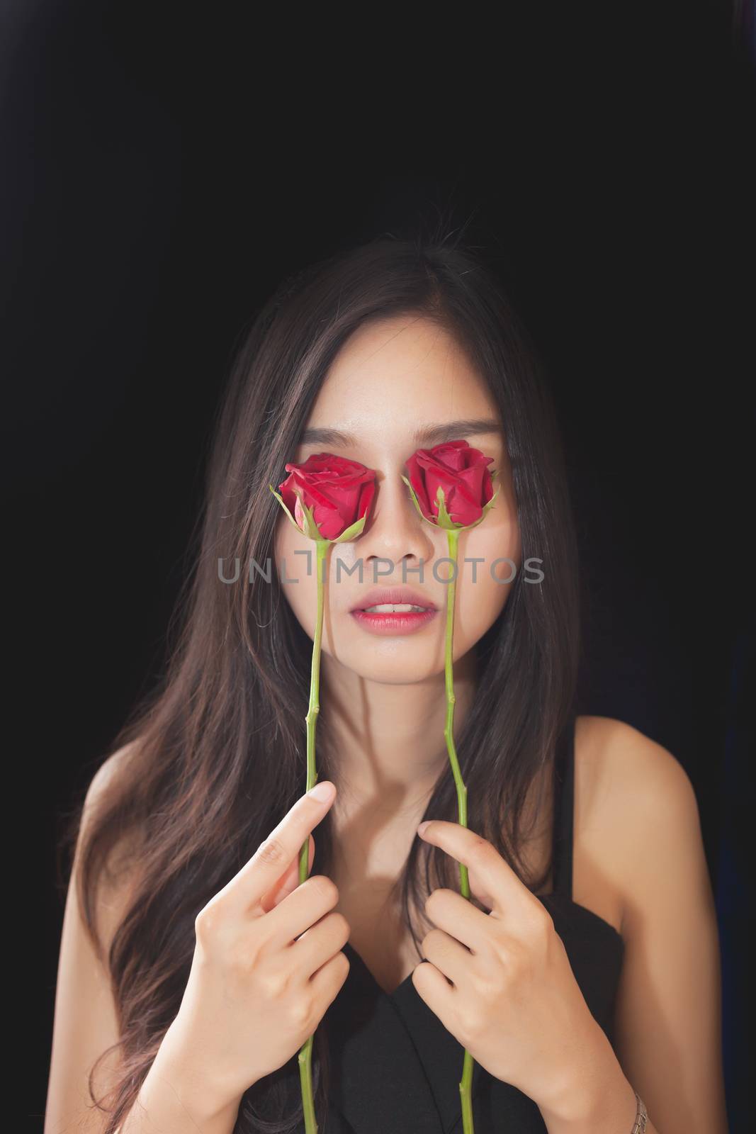 Beautiful asian women and red rose on black background .