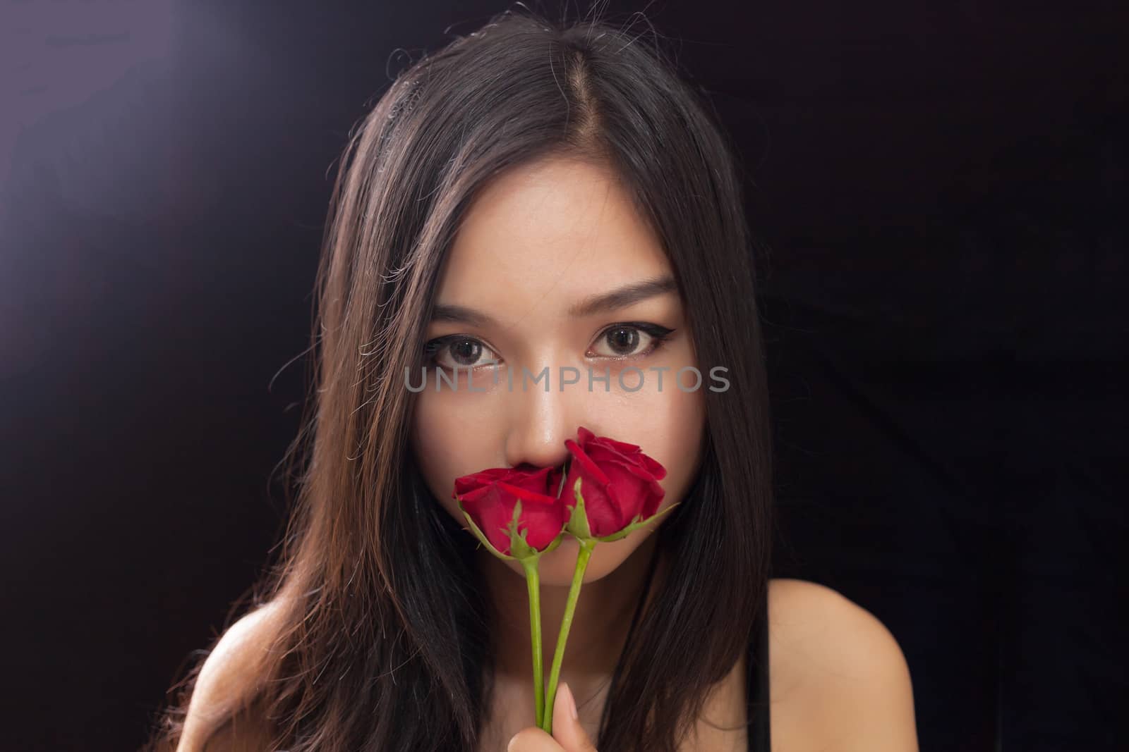 Beautiful asian women and red rose on black background by nopparats