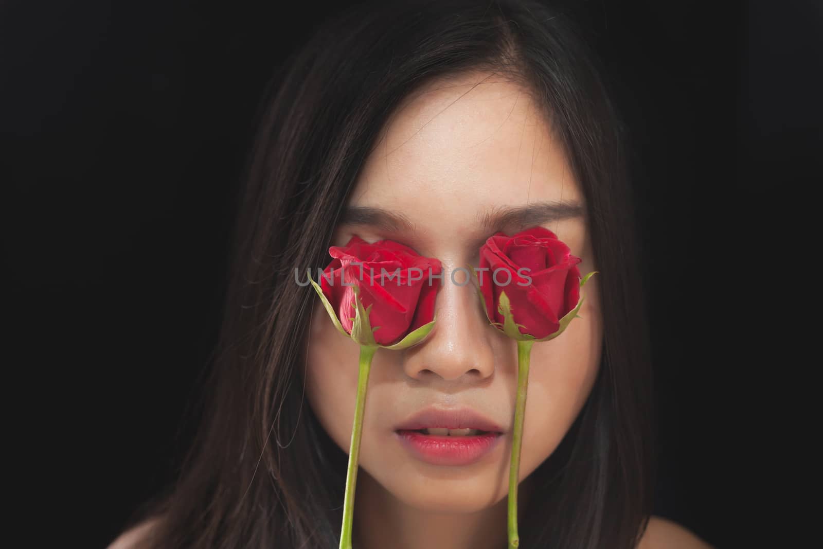 Beautiful asian women and red rose on black background by nopparats