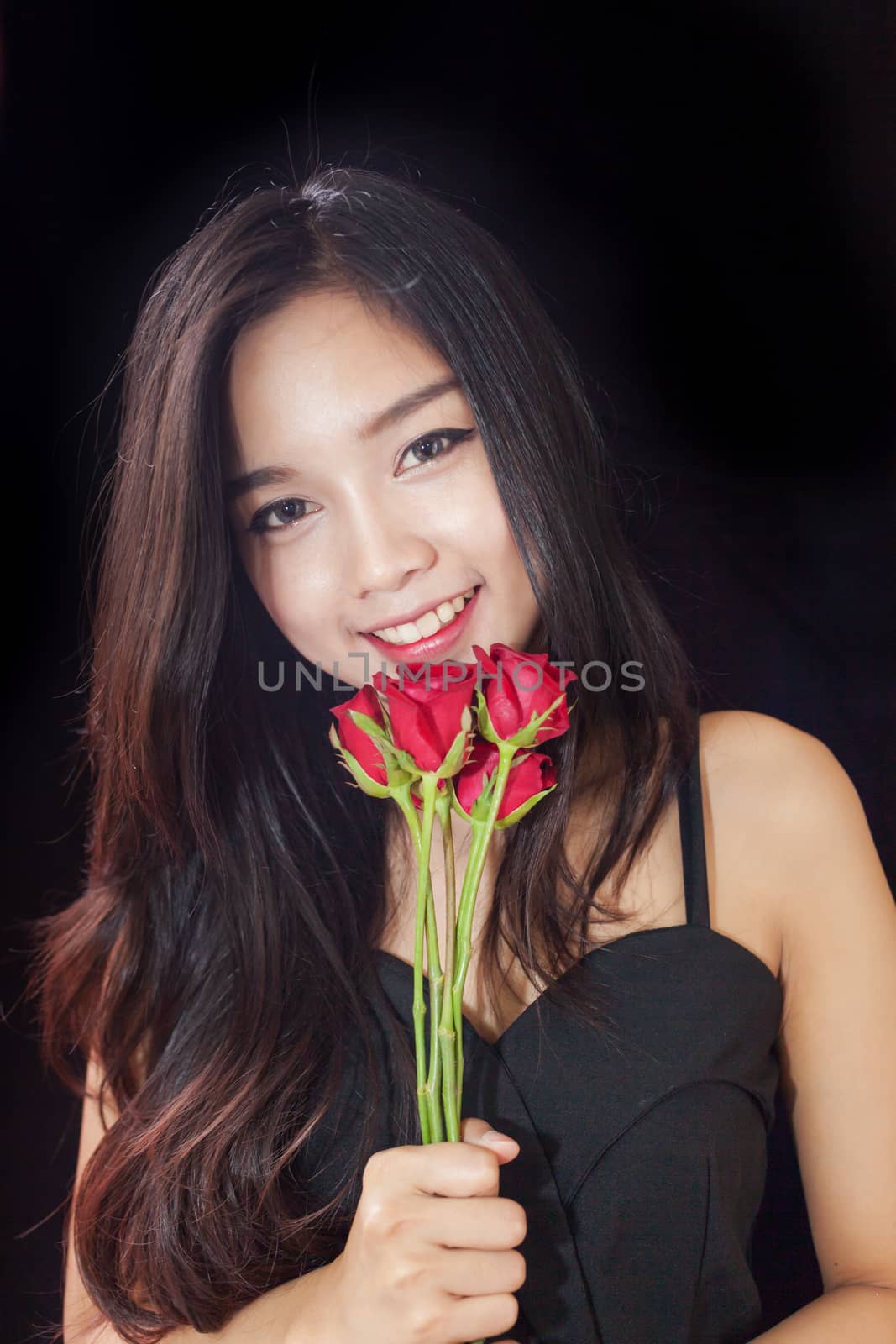 Beautiful asian women and red rose on black background .