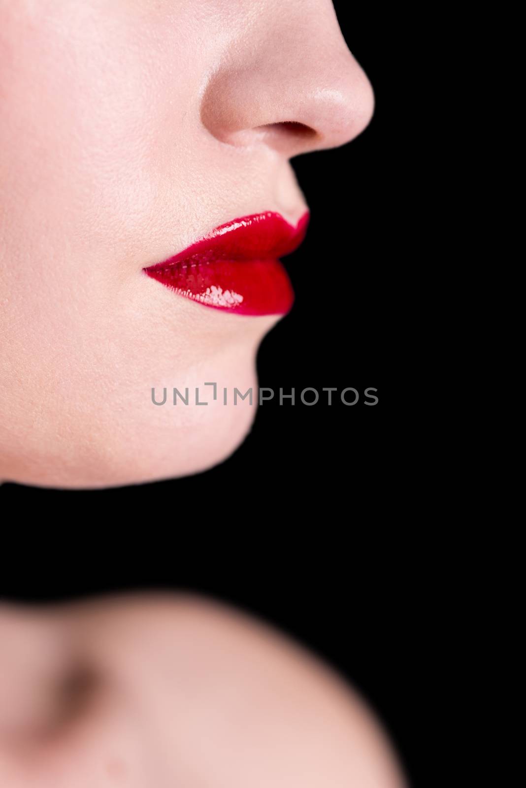 Close-up shot of woman lips with glossy red lipstick