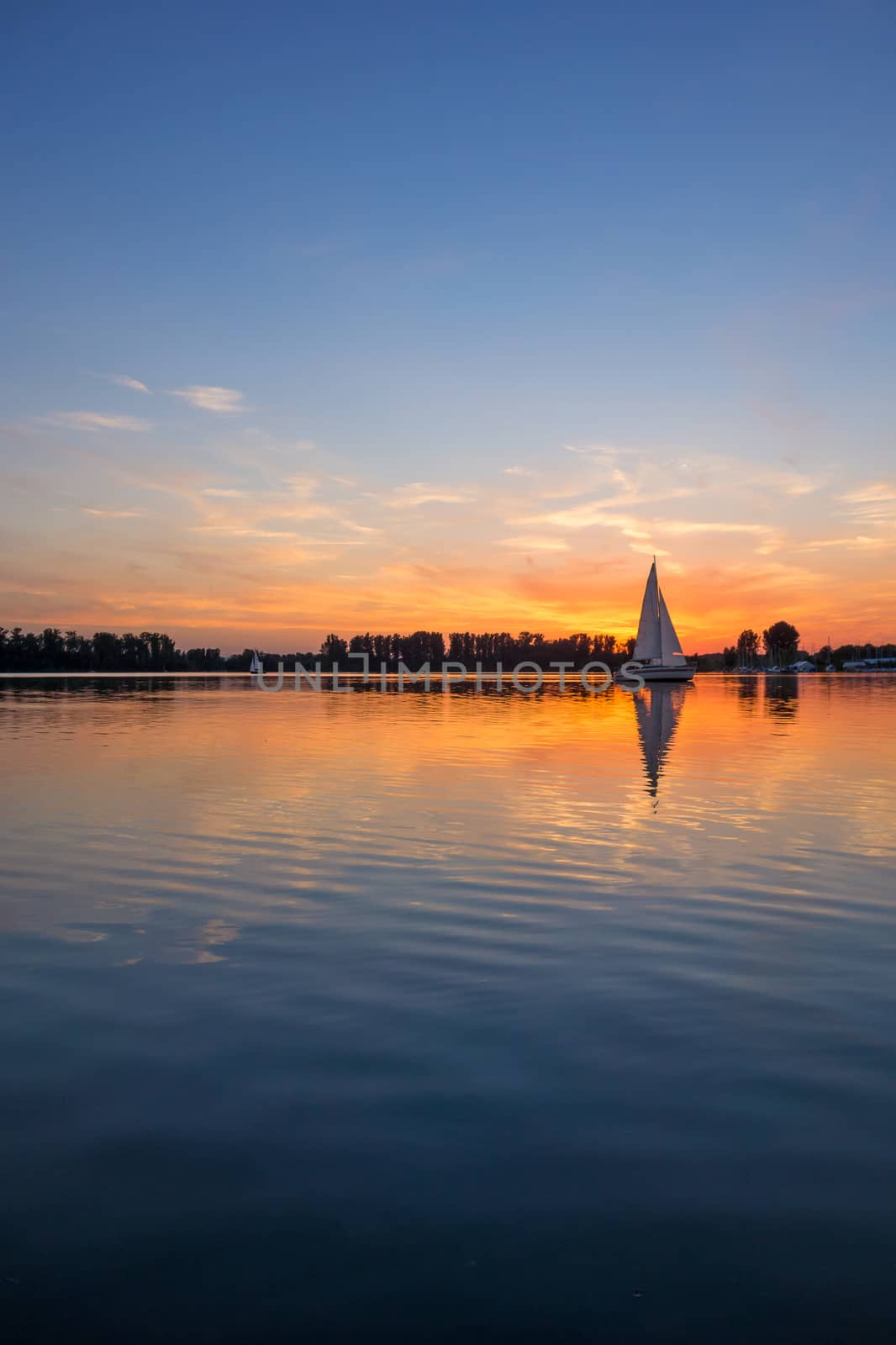 sunrise / sunset at a lake with sailing boats