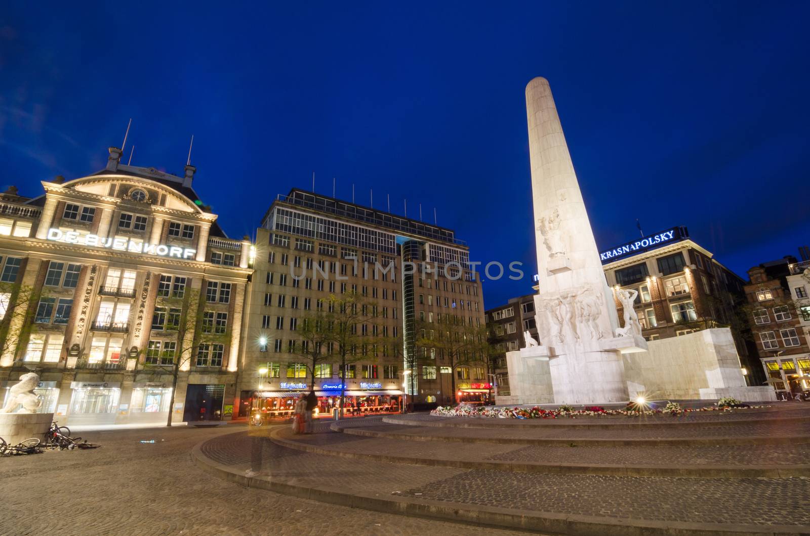 Amsterdam, Netherlands - May 7, 2015: People visit The Dam monument on May 7, 2015. The stone pillar is a National Monument, designed by J.J.P. Oud and erected in 1956 to memorialize the victims of the World War II.