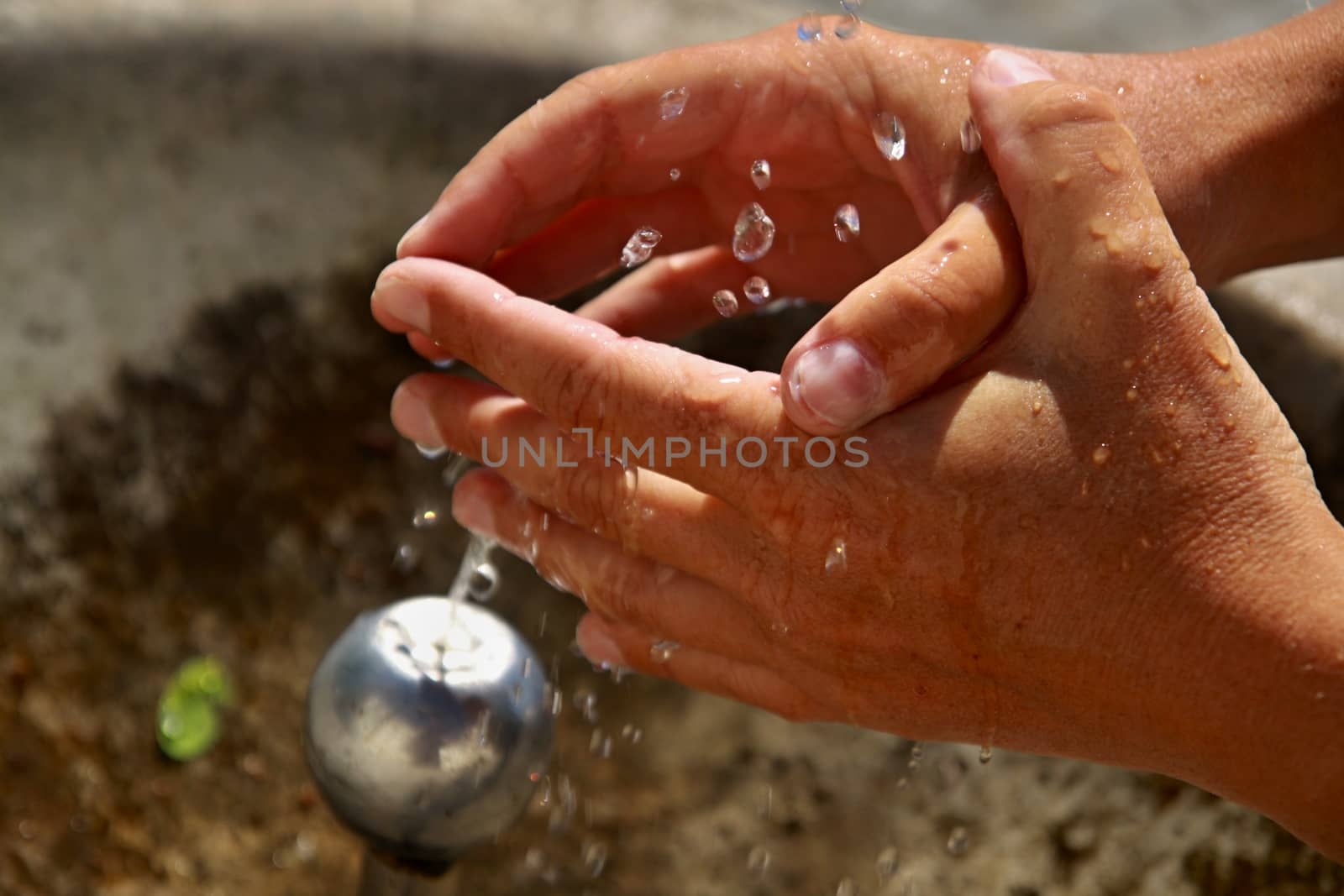 Woman's hands with water splash by jnerad