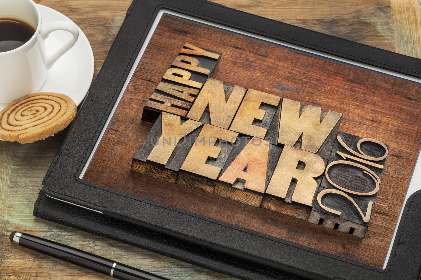 Happy New Year 2016 greetings  - text in vintage letterpress wood type blocks on a digital tablet with a cup of coffee