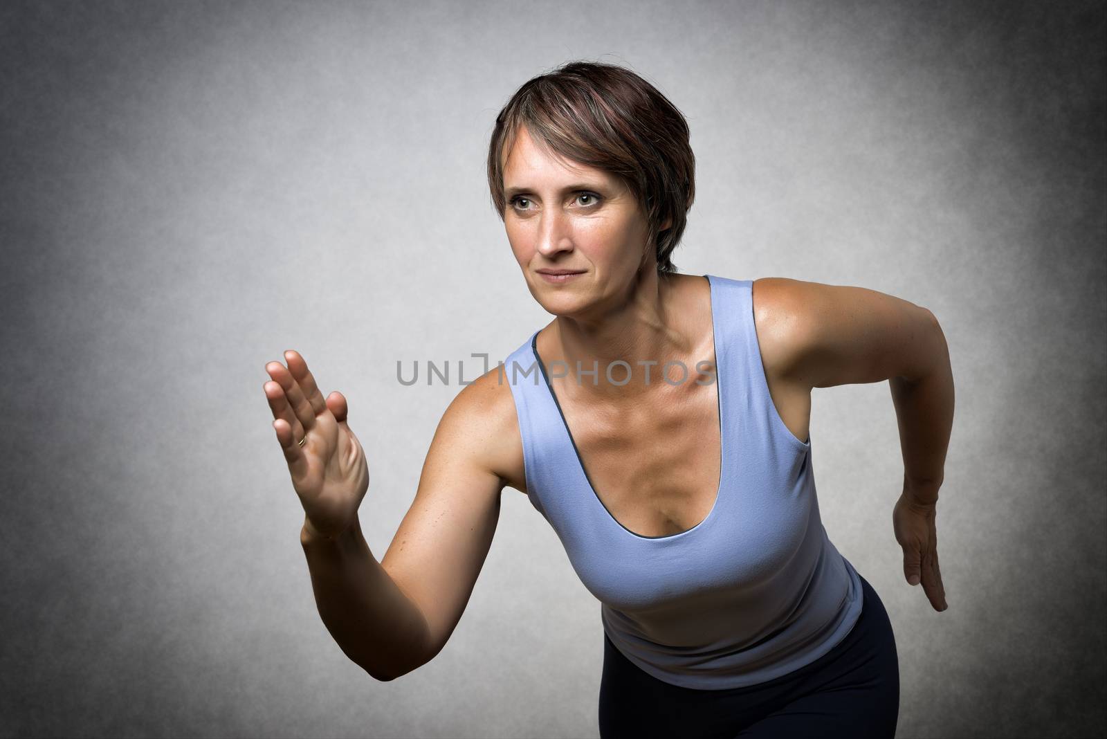 Image of running middle aged handsome woman in sportswear
