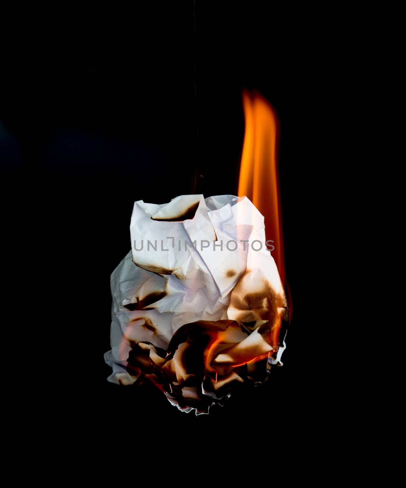 white crumpled  paper burning on black background