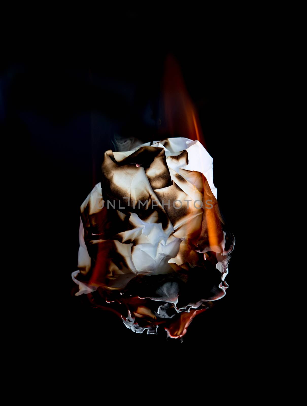 white crumpled  paper burning on black background