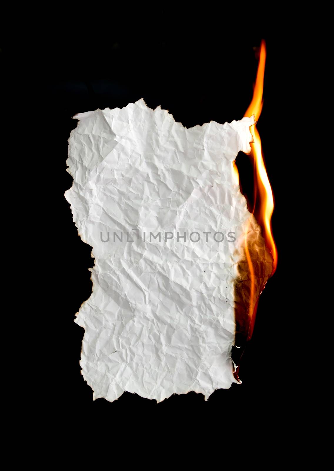 white crumpled  paper burning on black background