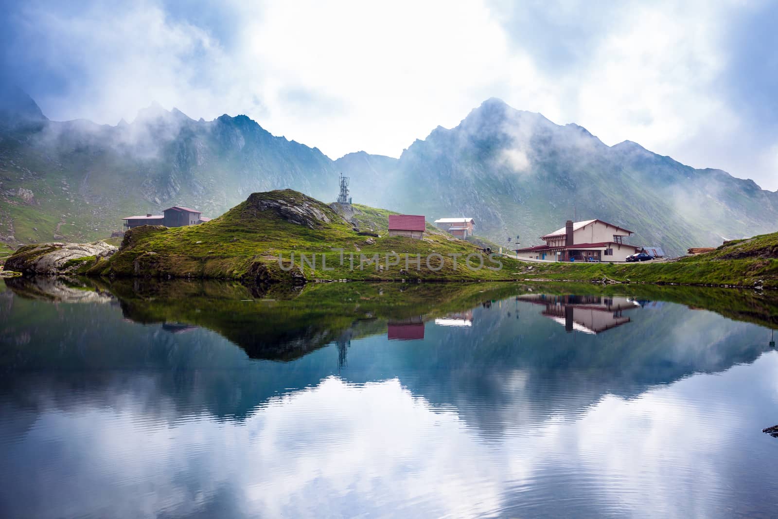 BALEA LAKE, ROMANIA - JUNE 24, 2012: Idyllic view with typical lodges on Balea Lake shore in Fagaras Mountains, Romania.