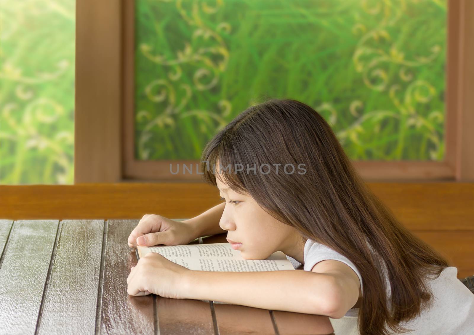 Asian girl bored learning while sitting at desk