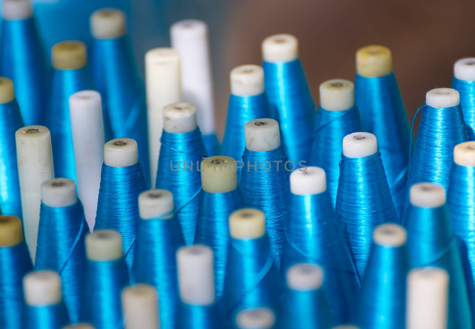 Bobbin for weaving silk,Spool of blue silk thread in row