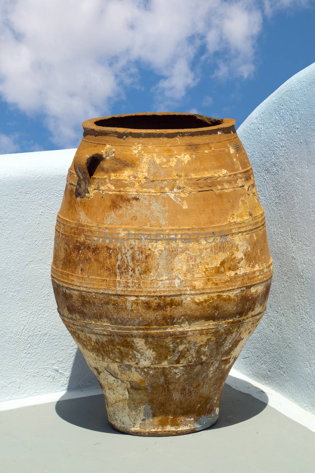 Greek amphora under blue sky on traditional balcony by papadimitriou