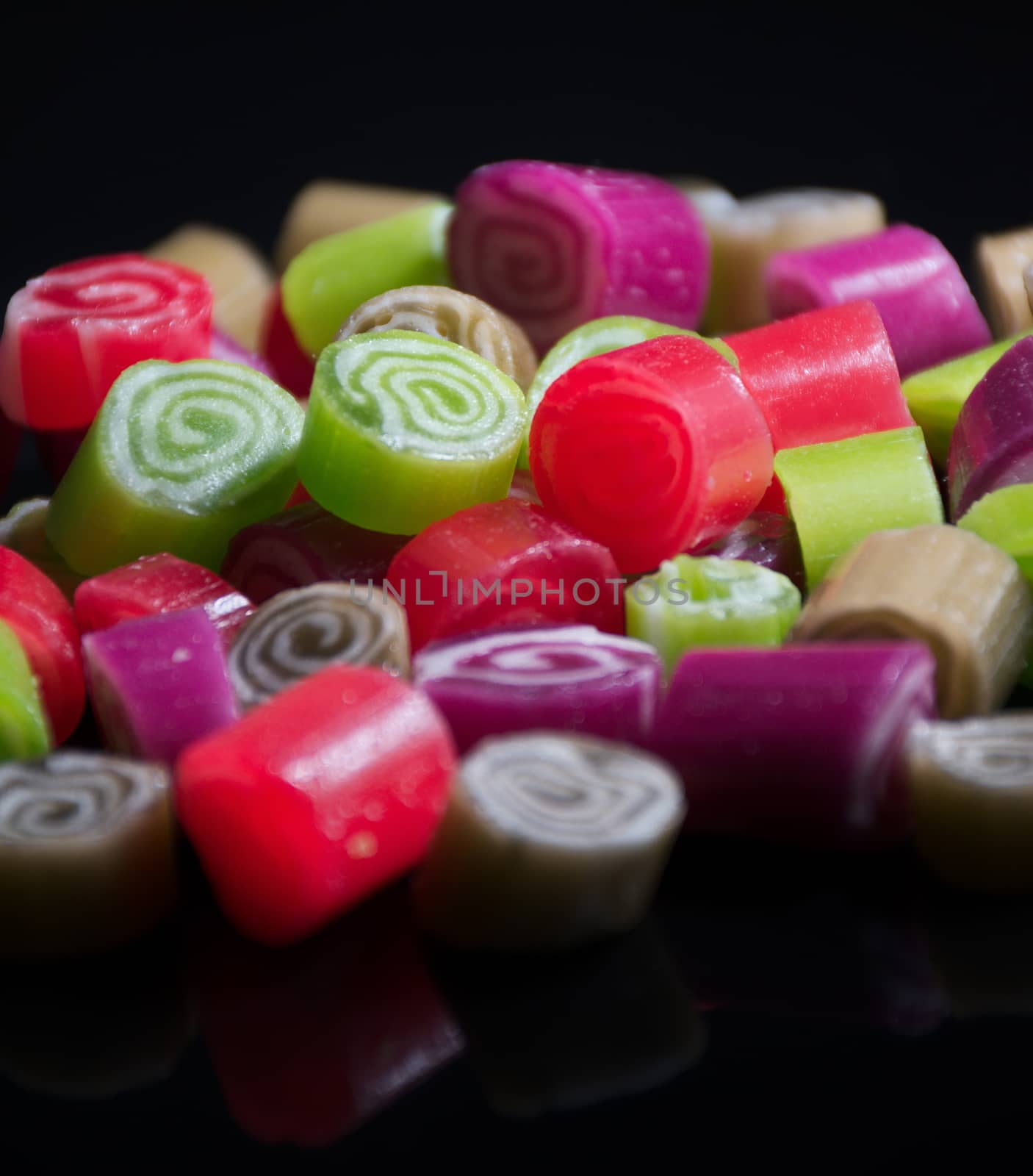 Colorful candies on black background by anderm