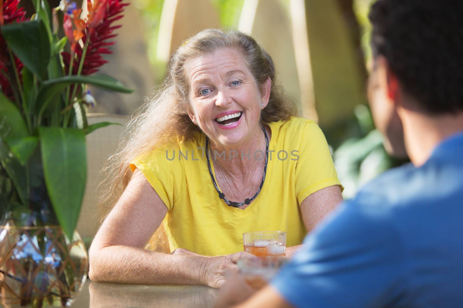 Laughing woman sitting at table with friend in Hawaii