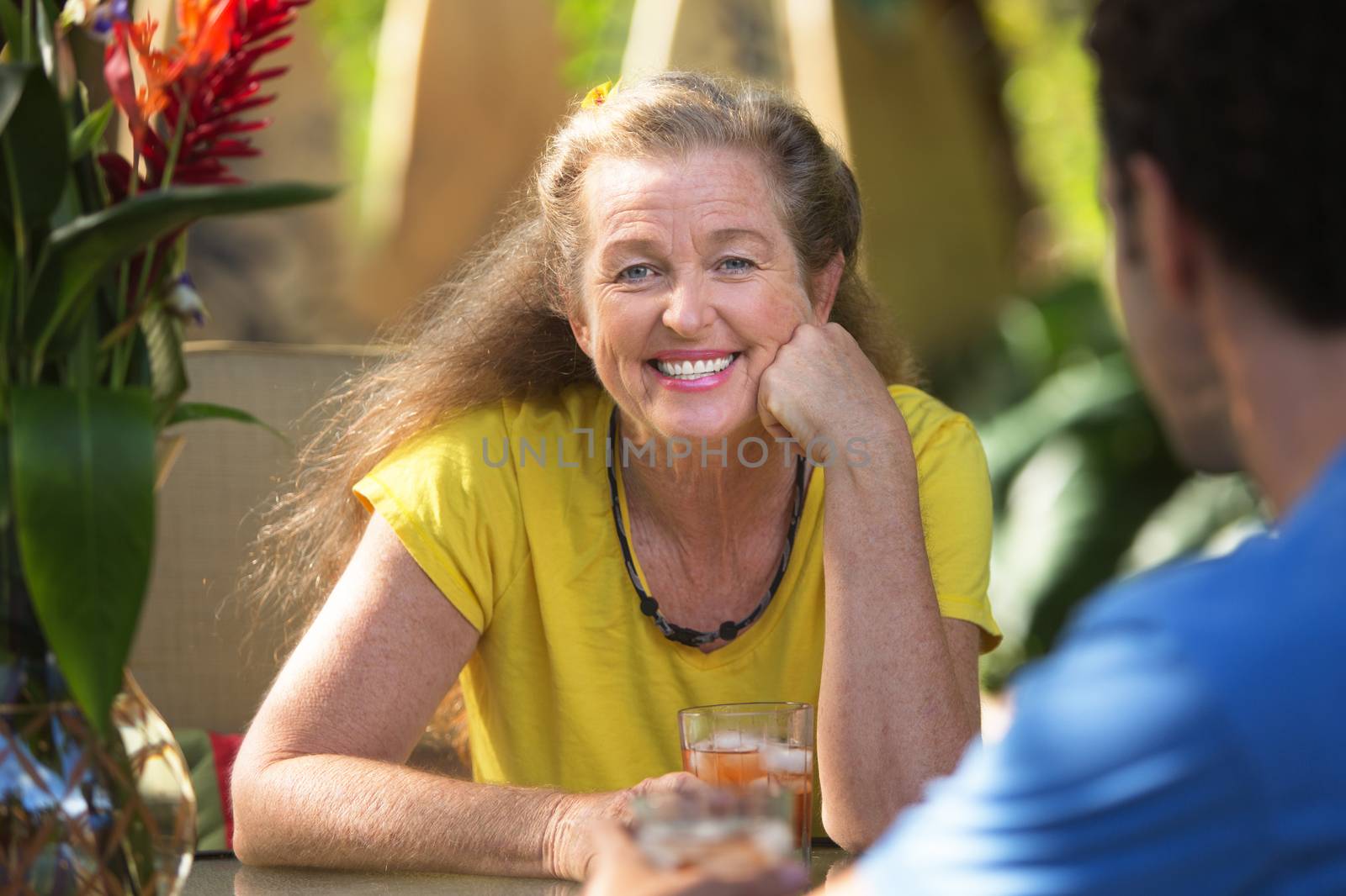 Smiling cheerful woman having drinking with friend
