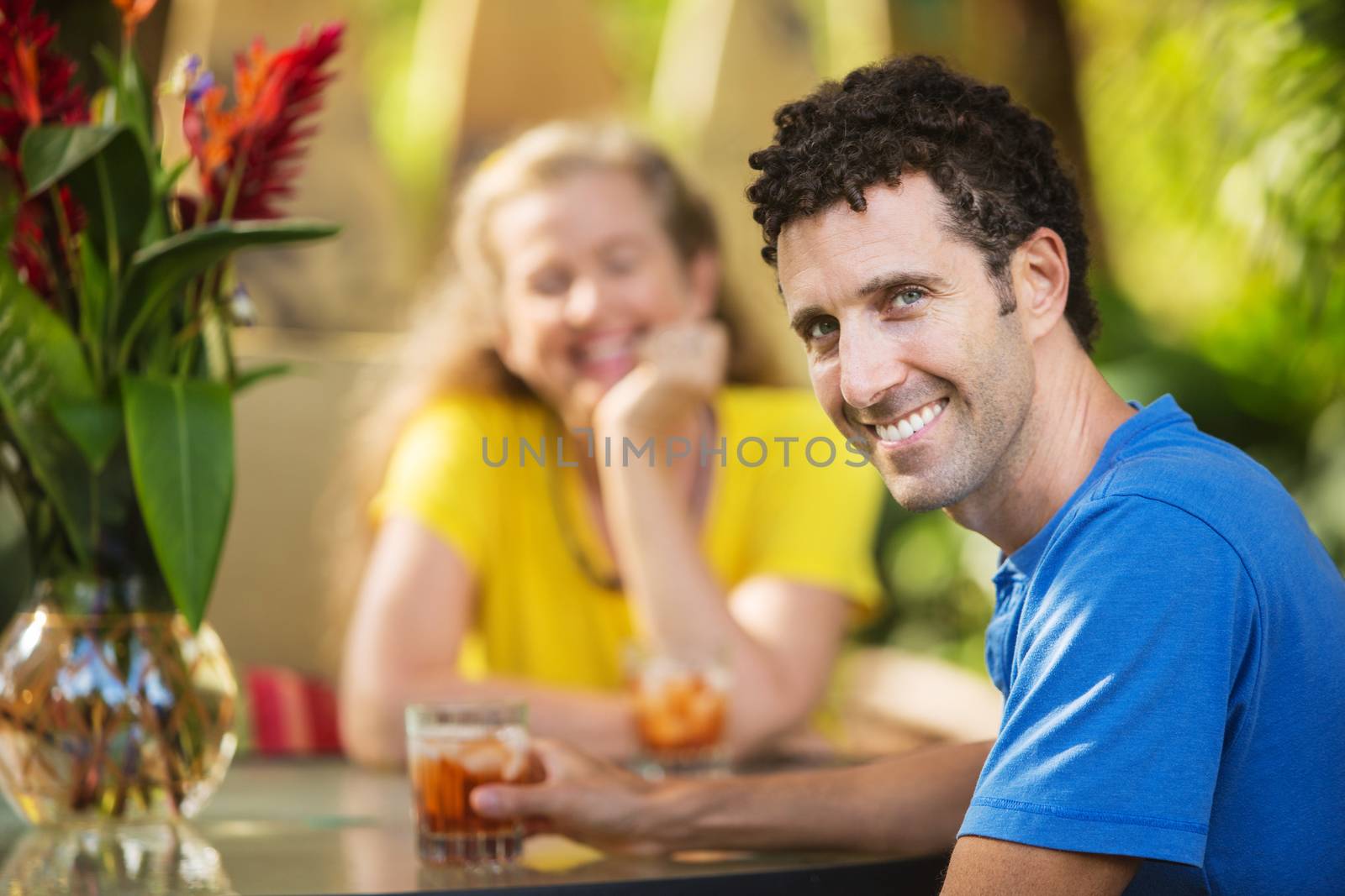Smiling man having drinks with woman outdoors