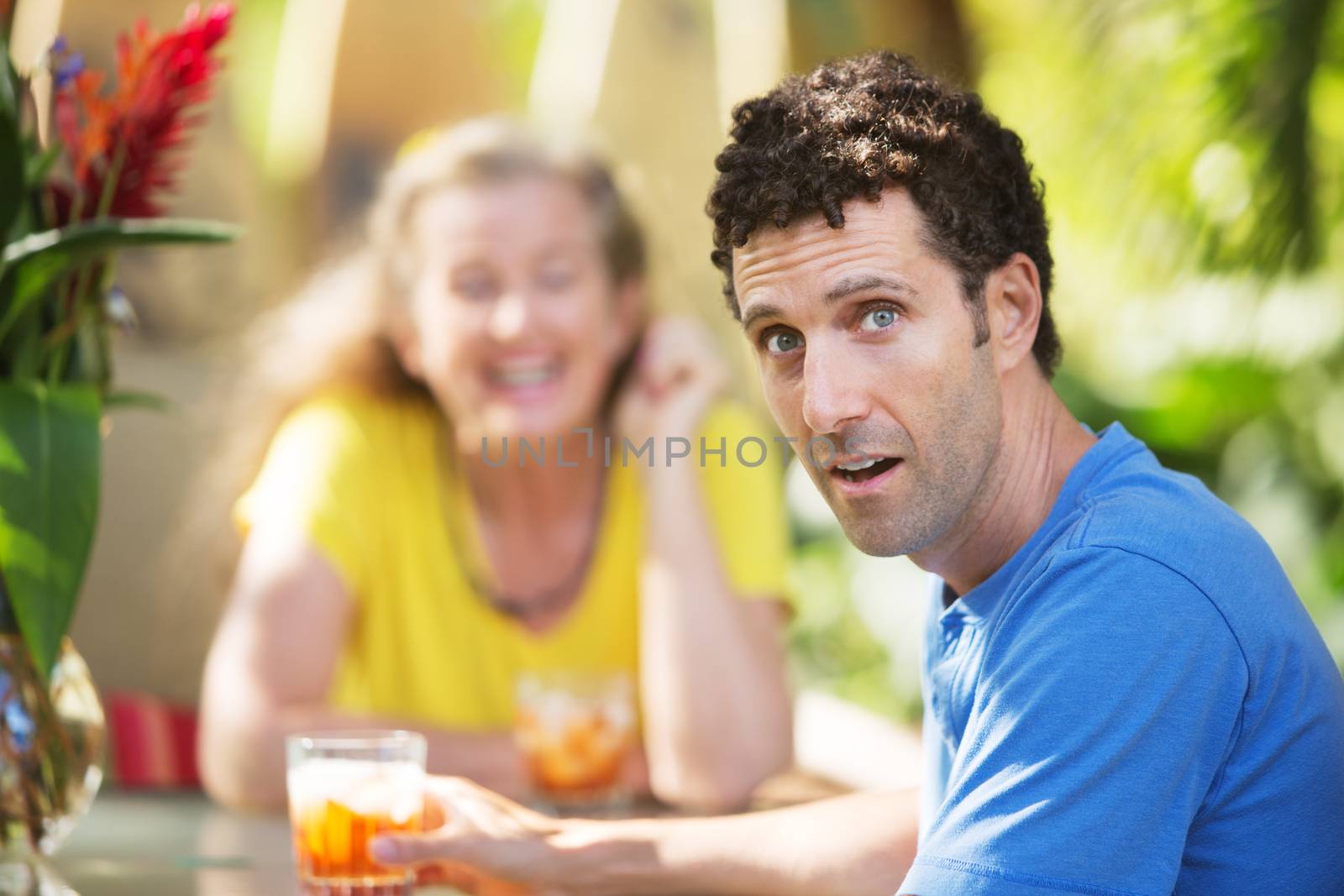 Dumbfounded Caucasian man with woman at table in Maui