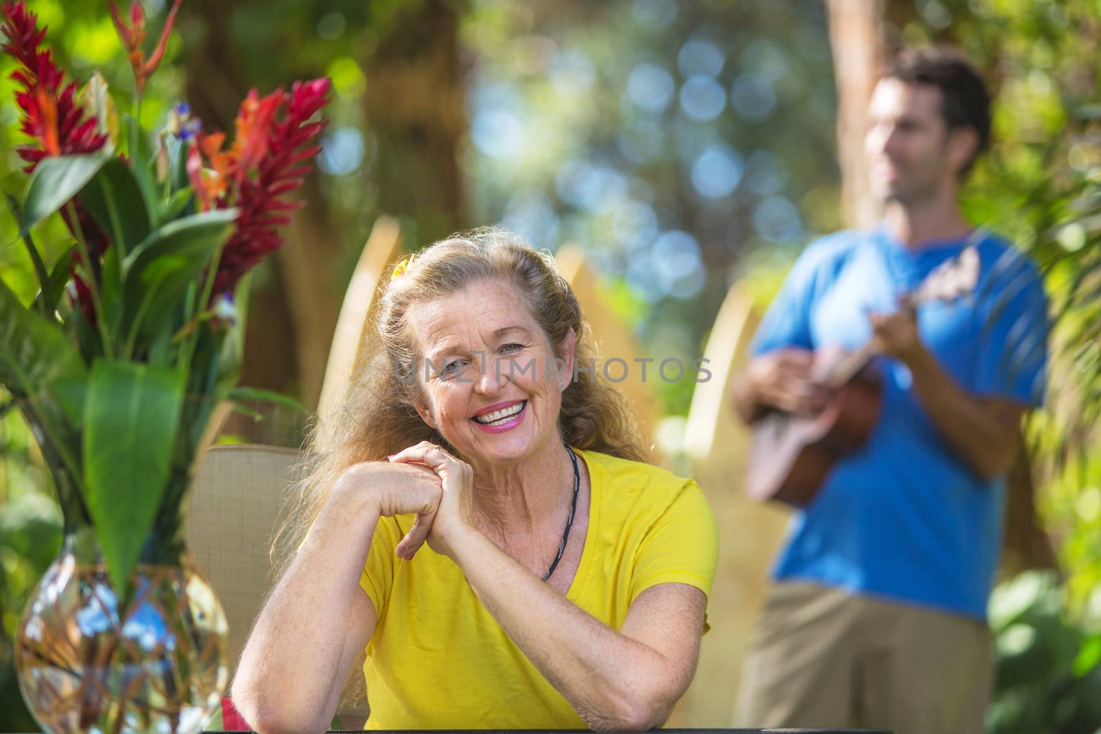 Beautiful enthusiastic senior woman and ukulele player on vacation