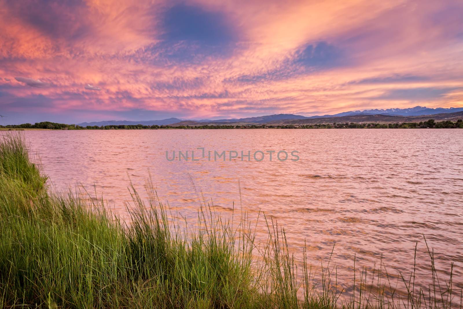 pink sunset cloudscape over lake by PixelsAway