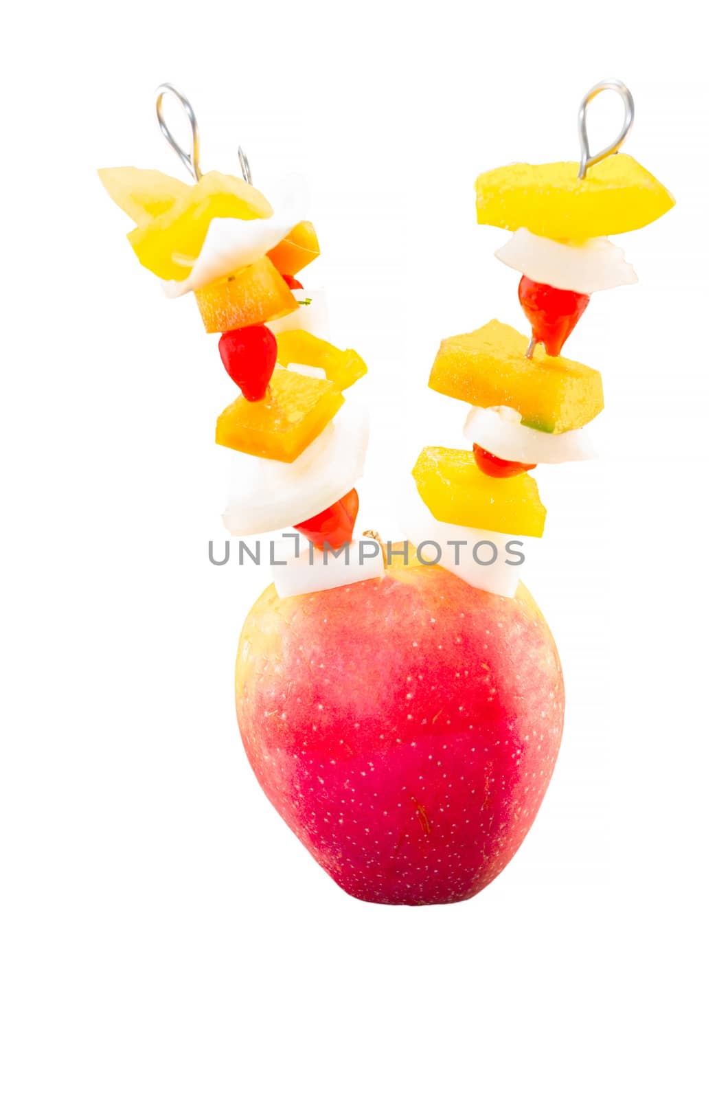 Vitamin-rich fruit skewers in an apple against white background.
