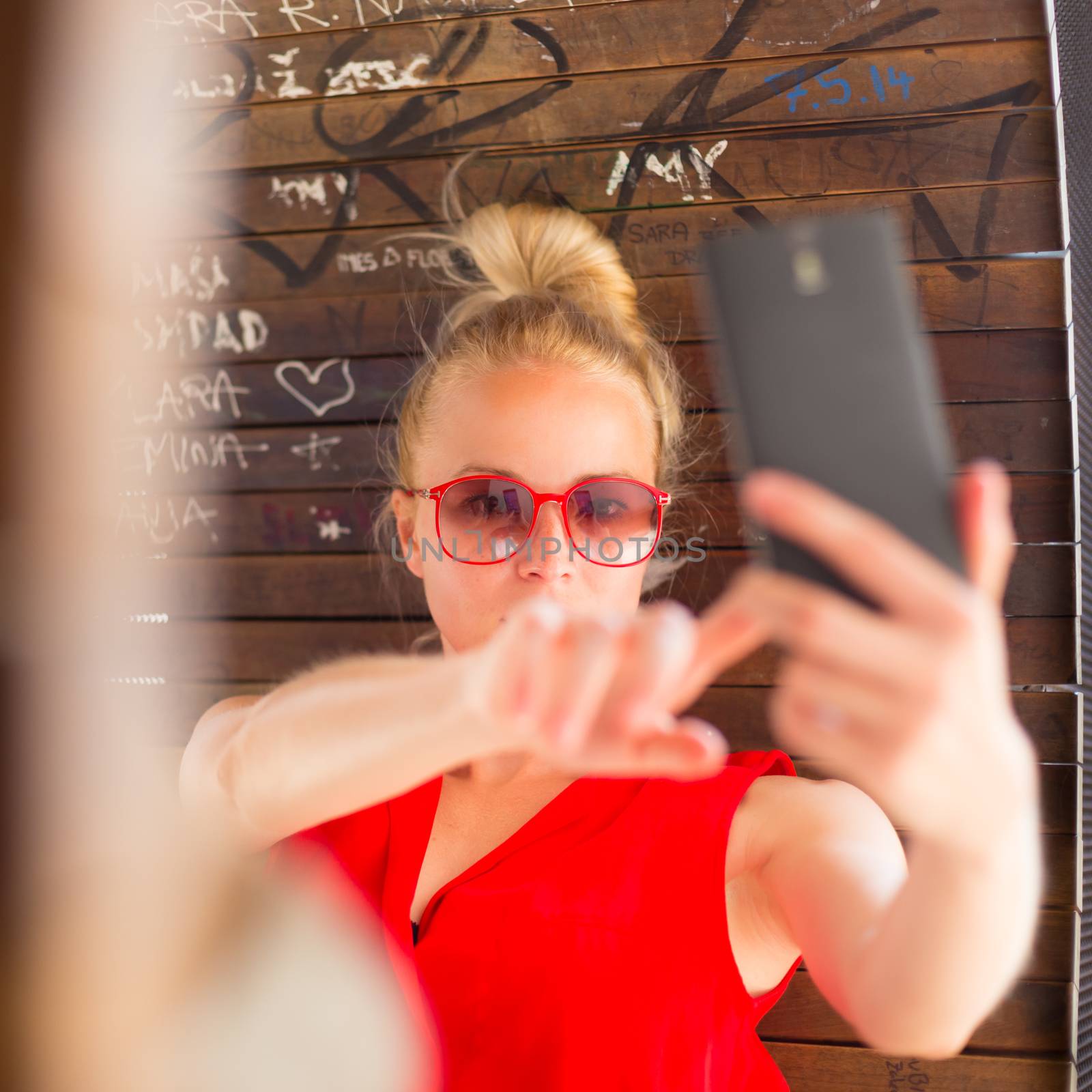 Young cheerful lady taking selfie. by kasto