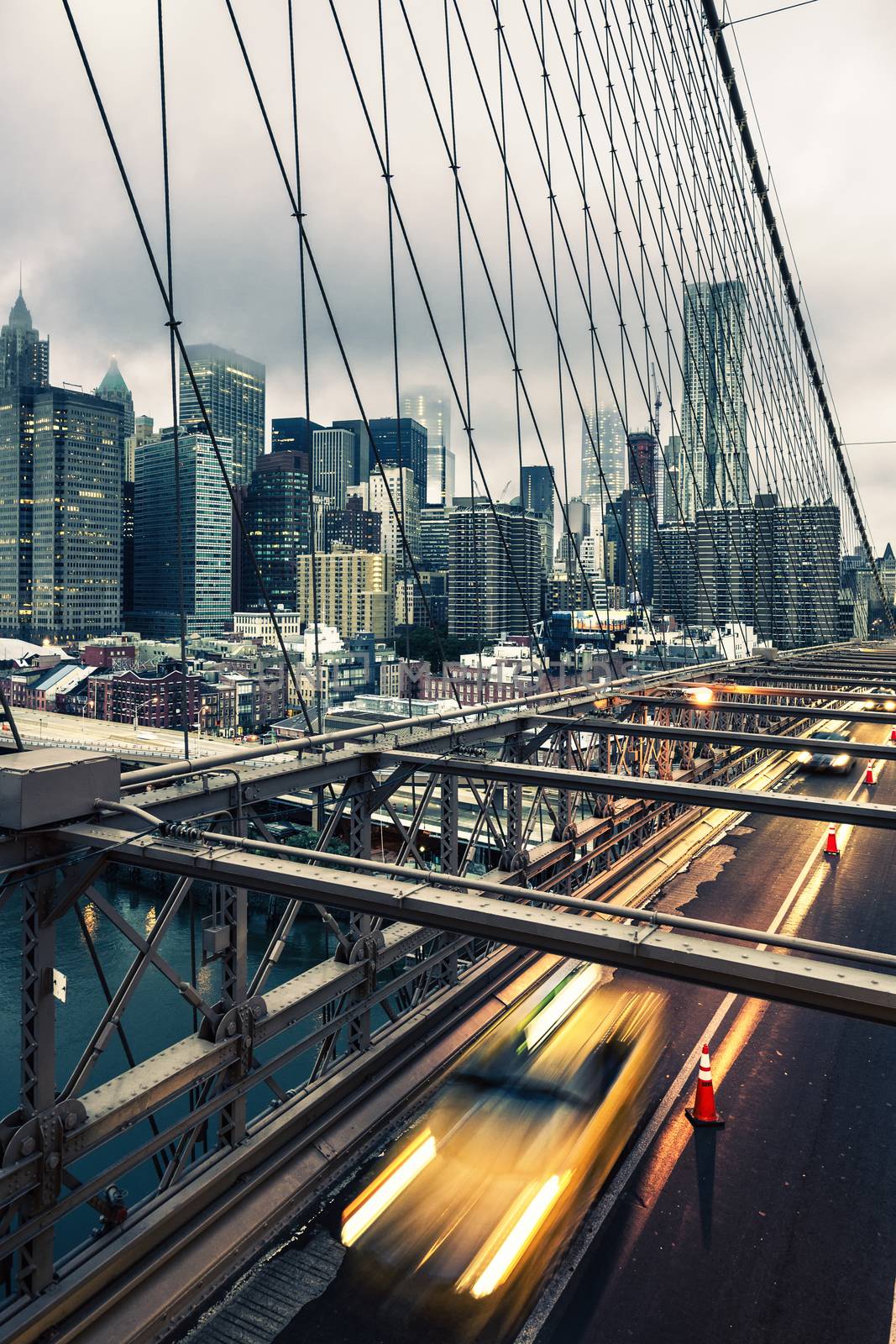 Taxi cab crossing the Brooklyn Bridge in New York, Manhattan skyline in background
