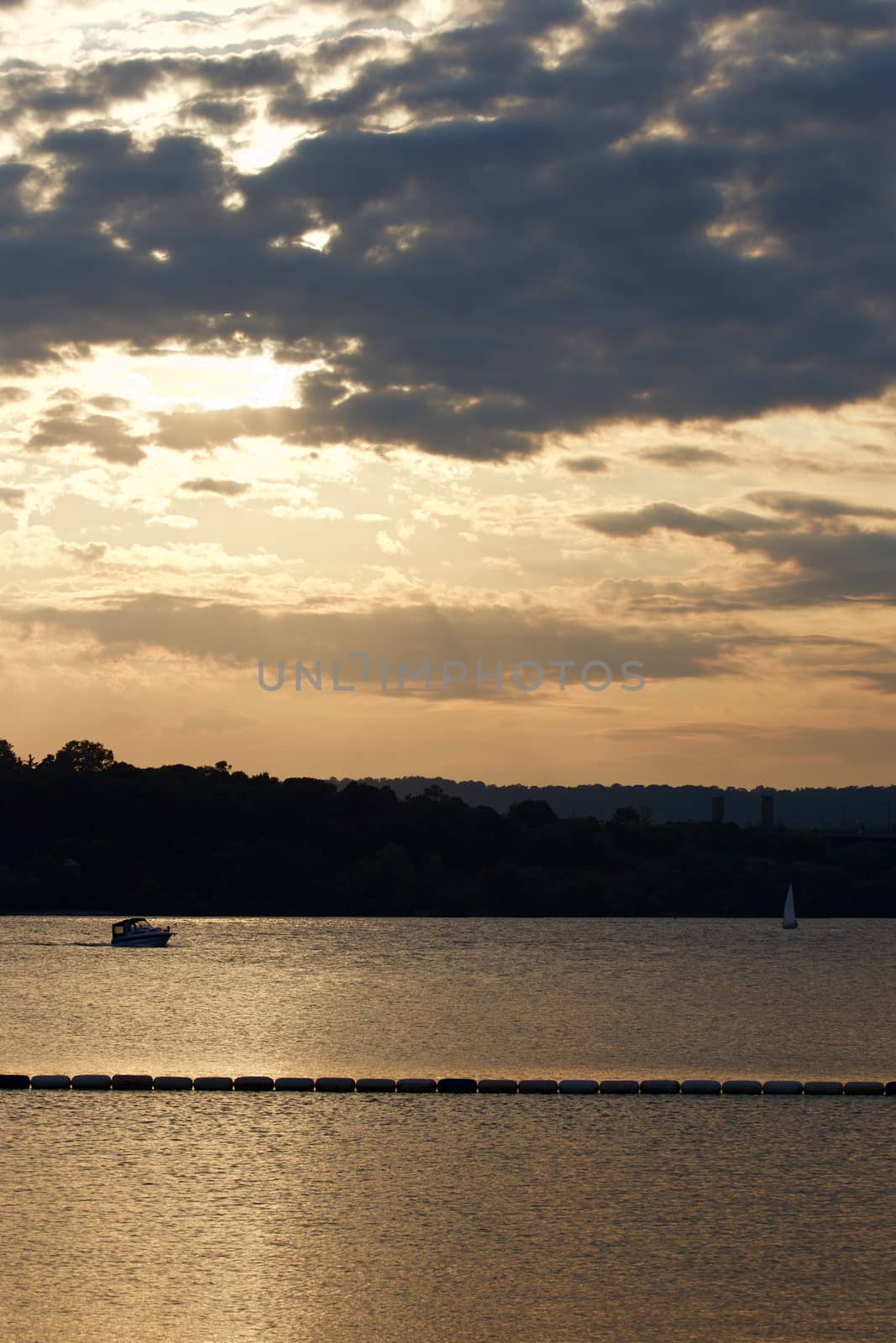 The beautiful sunset on the lake with two yachts